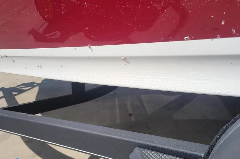 Slide: The Image of 2024 Tahoe 200 S boat hull with red and white paint, showing minor surface imperfections. - 22
