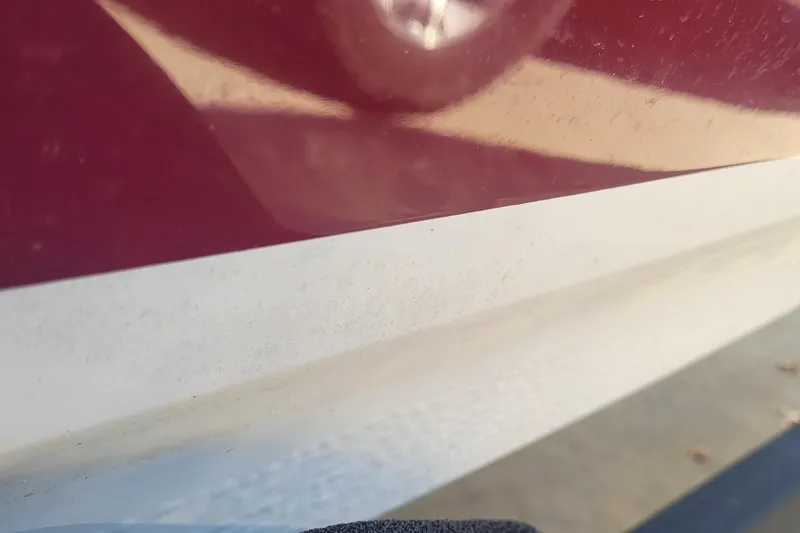 Slide: The Image of Close-up of a 2024 Tahoe 200 S boat's red and white exterior. - 24