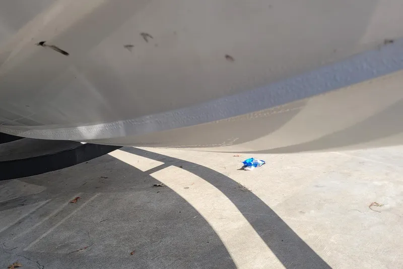 Slide: The Image of 2024 Tahoe 200 S boat hull on concrete surface, with shadows and debris. - 25