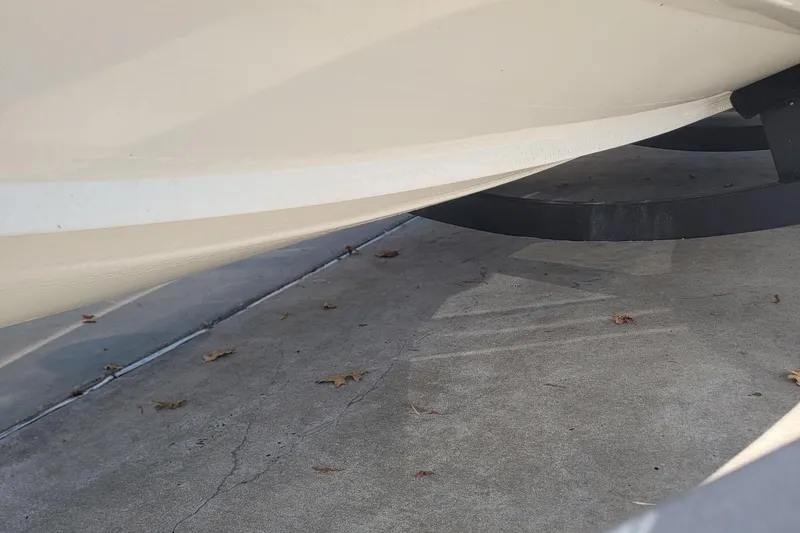 Slide: The Image of 2024 Tahoe 200 S boat hull on trailer, parked on concrete with scattered leaves. - 26