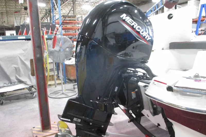 Slide: The Image of 2024 Tahoe 200 S boat with Mercury outboard motor in a warehouse setting. - 27