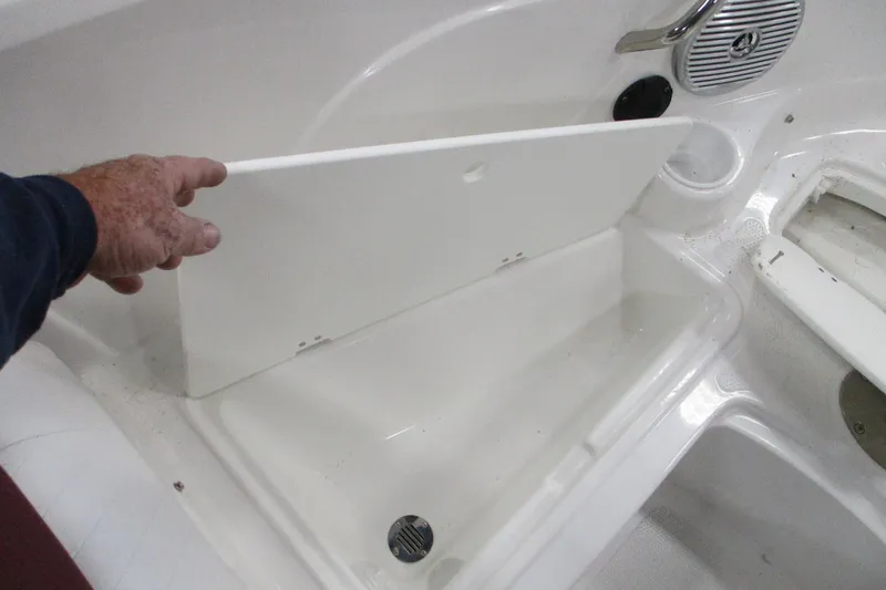 Slide: The Image of 2024 Tahoe 200 S boat storage compartment with open lid and drain plug. - 8