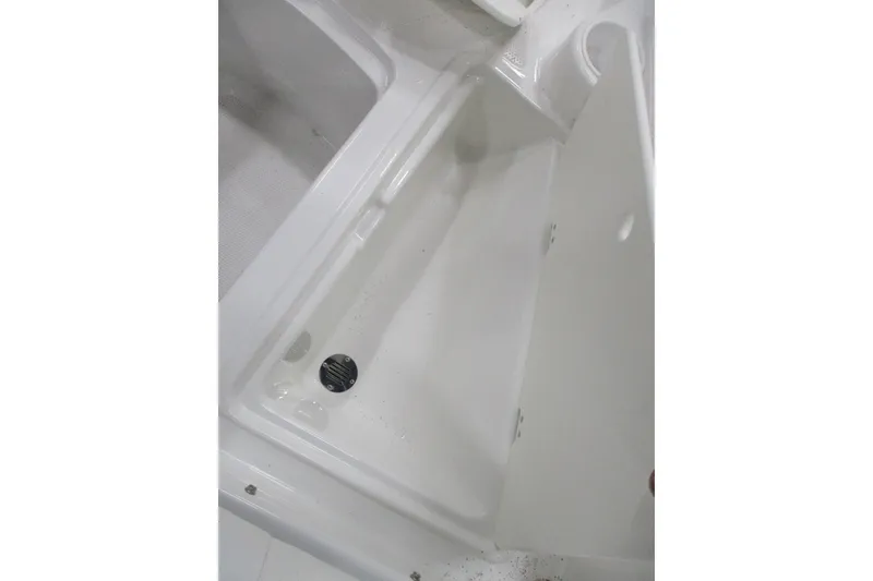 Slide: The Image of 2024 Tahoe 200 S boat storage compartment, open and empty, with white interior. - 9