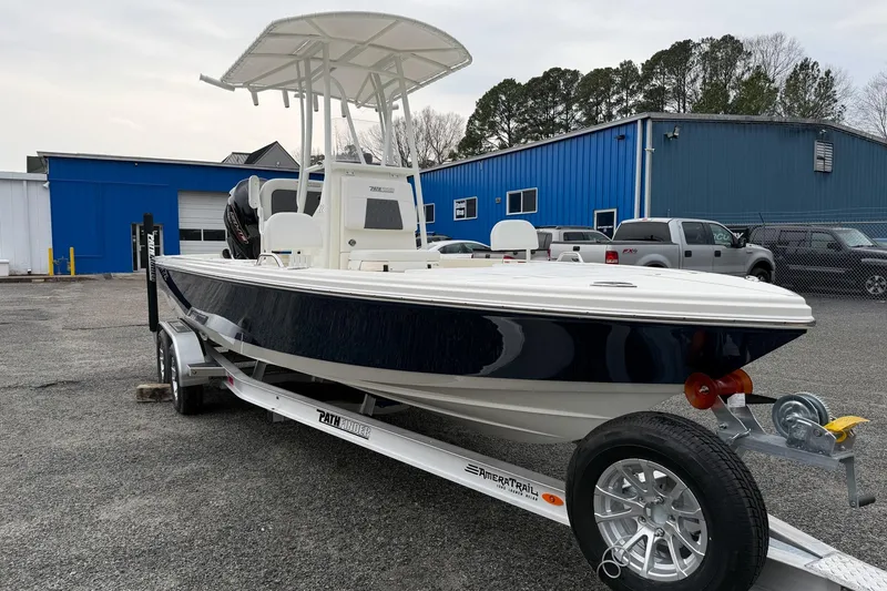 Slide: The Image of 2026 Pathfinder 2200 TRS boat on trailer, parked outside blue building. - 10