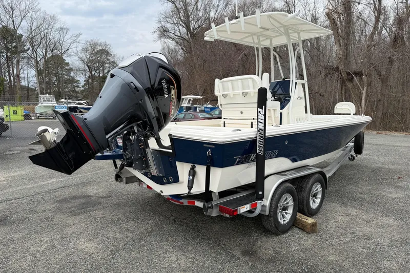 Slide: The Image of 2026 Pathfinder 2200 TRS boat on trailer with powerful outboard motor, parked outdoors. - 12