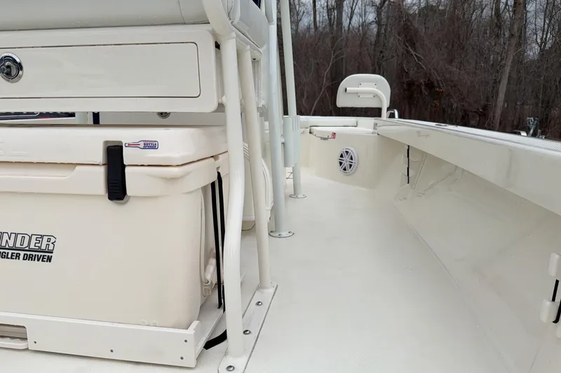 Slide: The Image of 2026 Pathfinder 2200 TRS boat interior with storage and seating, surrounded by trees. - 18