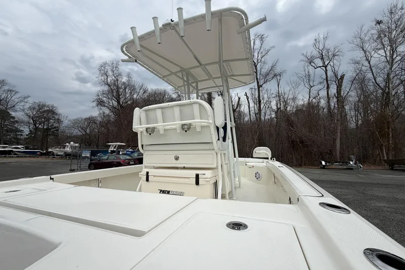 Slide: The Image of 2026 Pathfinder 2200 TRS boat with T-top, parked outdoors on a cloudy day. - 19