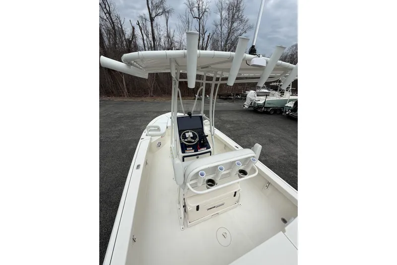 Slide: The Image of 2026 Pathfinder 2200 TRS boat with T-top and console, parked outdoors. - 20