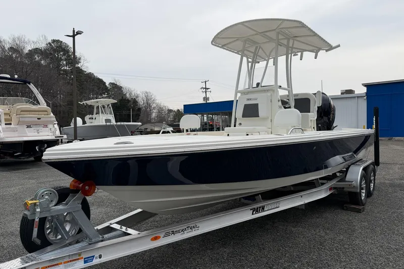 Slide: The Image of 2026 Pathfinder 2200 TRS boat on trailer, parked outdoors near other boats. - 8