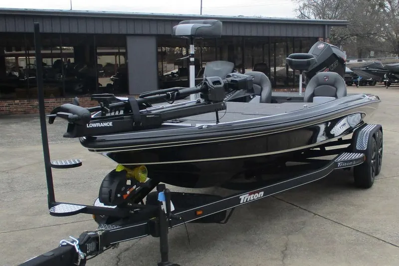 Slide: The Image of 2026 Triton 21XP Patriot boat with Lowrance equipment, parked outdoors. - 6