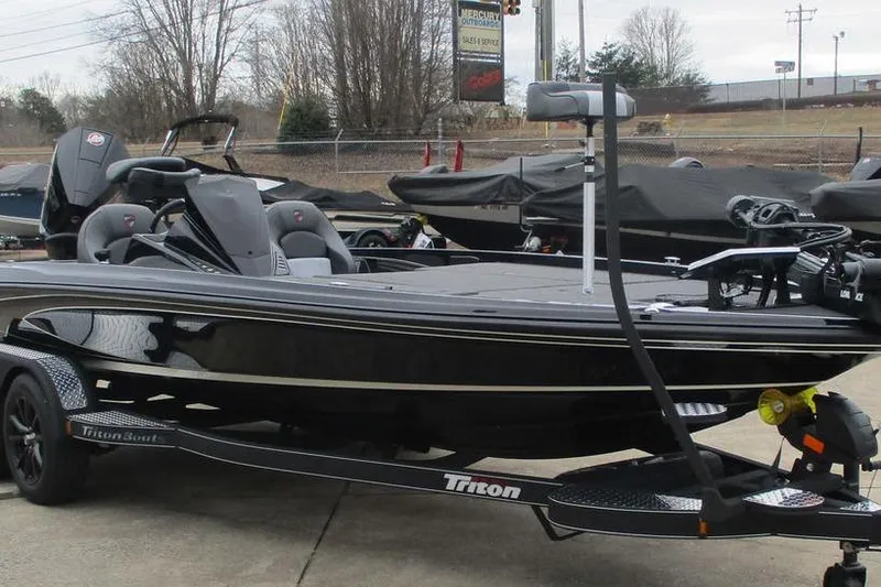 Slide: The Image of 2026 Triton 21XP Patriot boat on trailer, sleek black design, parked outdoors. - 8