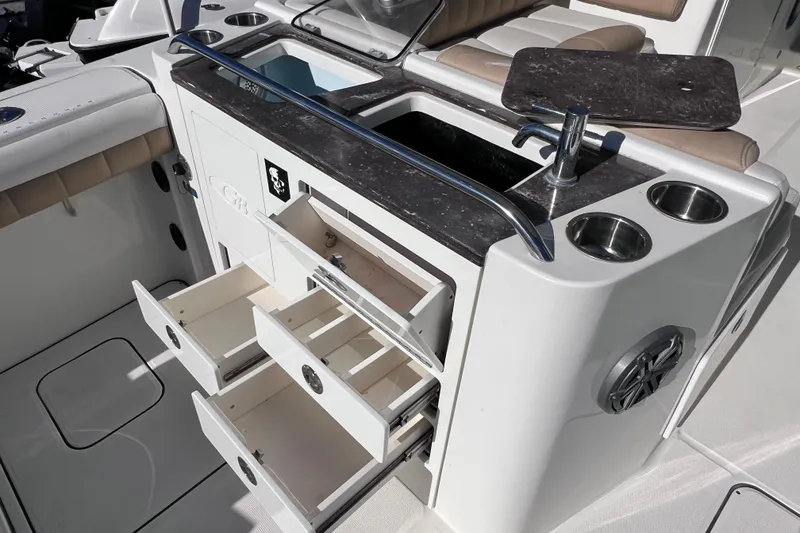Slide: The Image of 2017 World Cat Glacier Bay Edition 2740 boat interior with open storage drawers and sink. - 19