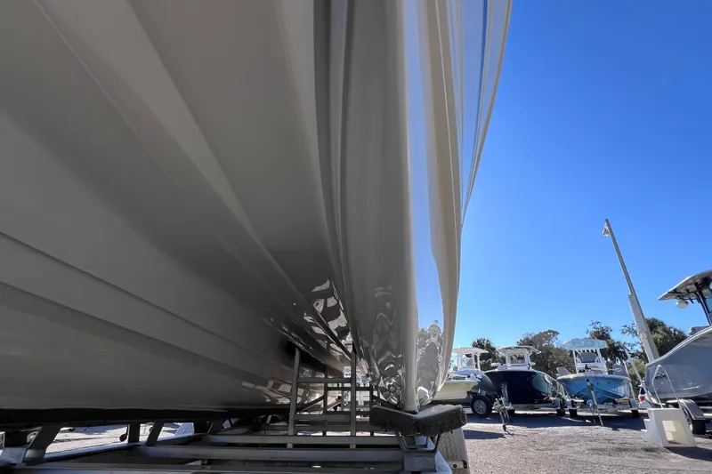 Slide: The Image of 2017 World Cat Glacier Bay Edition 2740 Dual Console boat hull on trailer, clear sky background. - 7