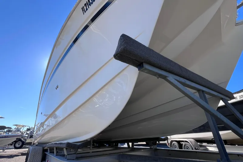 Slide: The Image of 2017 World Cat Glacier Bay Edition 2740 Dual Console on trailer, under clear blue sky. - 9