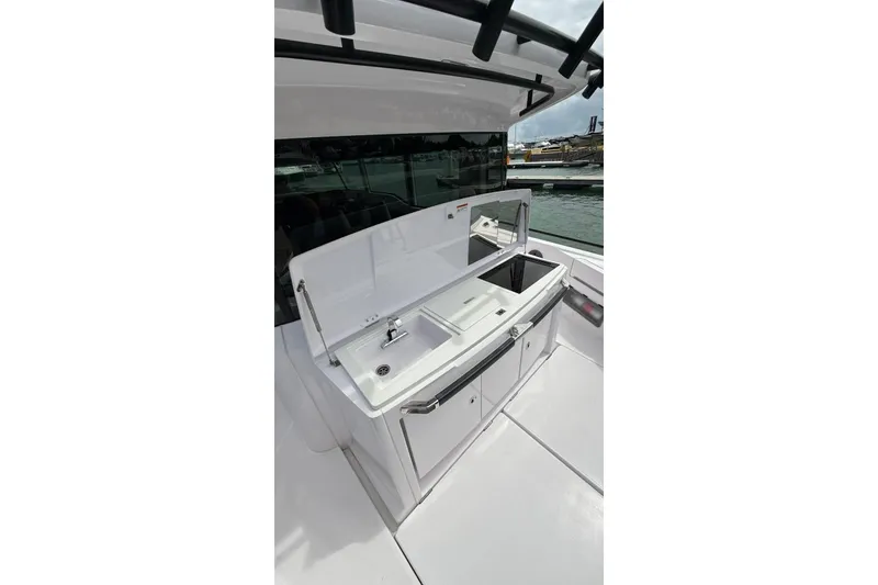 Slide: The Image of 2025 Axopar 37 XC Cross Cabin boat with outdoor sink and storage area. - 2