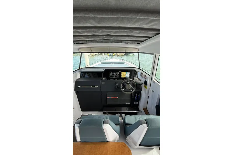 Slide: The Image of 2025 Axopar 37 XC Cross Cabin interior with modern dashboard and steering wheel. - 3