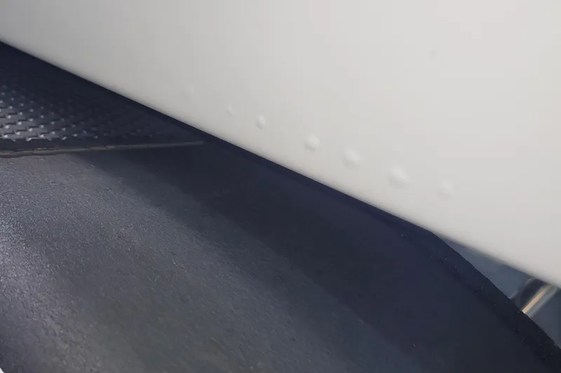 Slide: The Image of Close-up of 2024 Tahoe 2150 CC boat hull with textured surface detail. - 7