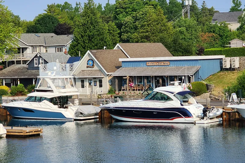 Slide: The Image of 2020 Tiara Yachts F44 Flybridge docked near charming waterfront shops. - 12