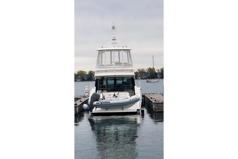 Slide: The Image of 2020 Tiara Yachts F44 Flybridge docked at marina, rear view. - 15