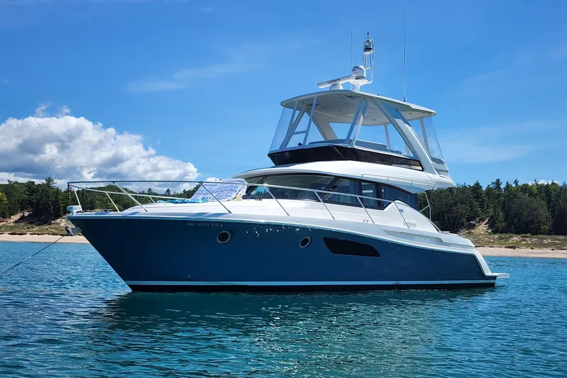 Slide: The Image of 2020 Tiara Yachts F44 Flybridge on clear blue water, scenic background. - 2