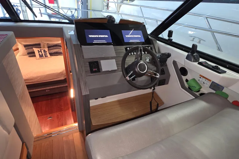 Slide: The Image of 2020 Tiara Yachts F44 Flybridge interior with helm, steering wheel, and cozy cabin. - 27