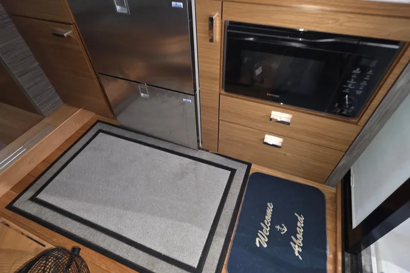 Slide: The Image of 2020 Tiara Yachts F44 Flybridge interior with kitchen appliances and welcome mat. - 28