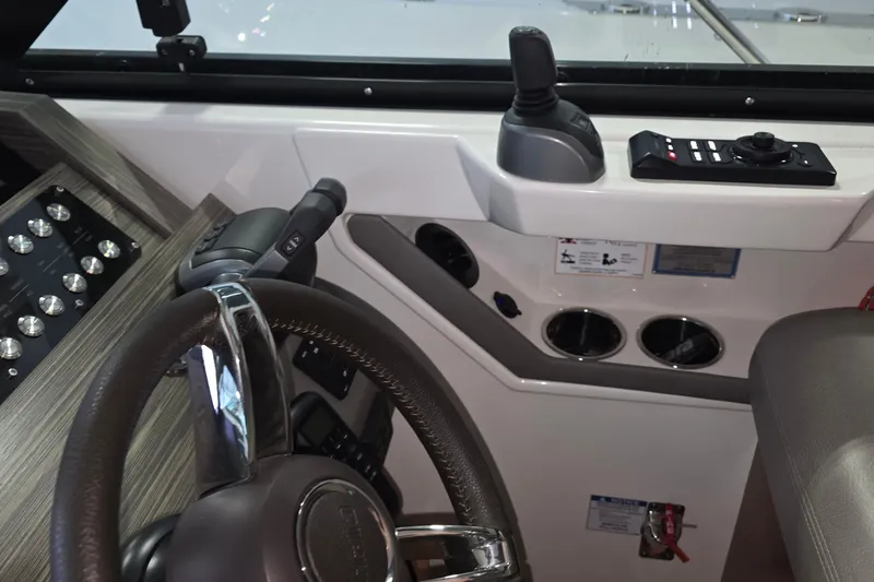 Slide: The Image of 2020 Tiara Yachts F44 Flybridge helm with steering wheel and control panel. - 32