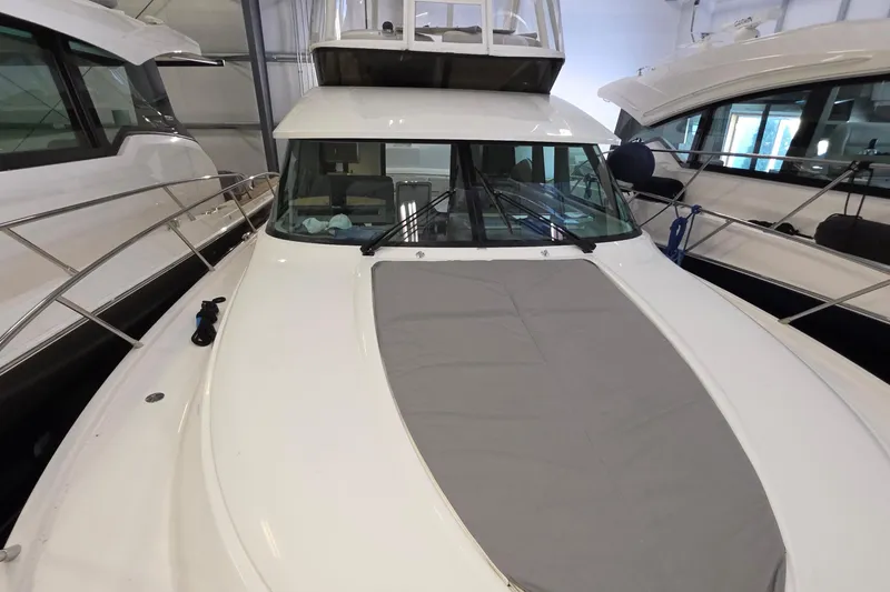 Slide: The Image of 2020 Tiara Yachts F44 Flybridge in a showroom, showcasing sleek design and spacious deck. - 48