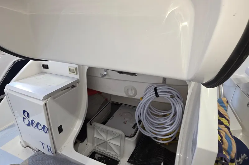 Slide: The Image of 2020 Tiara Yachts F44 Flybridge storage compartment with coiled hose and equipment. - 57