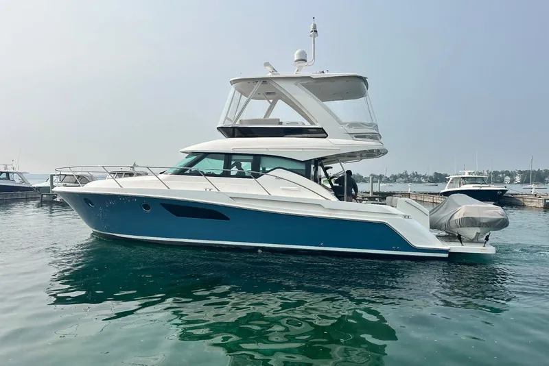 Slide: The Image of 2020 Tiara Yachts F44 Flybridge in marina, sleek design, blue hull, modern flybridge. - 6