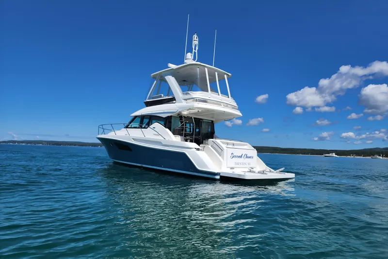 Slide: The Image of 2020 Tiara Yachts F44 Flybridge on serene blue water under clear sky. - 8