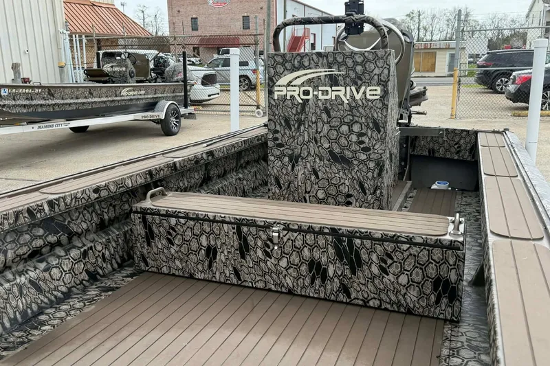 Slide: The Image of 2026 Pro-Drive 2054 X Series TD boat with camouflage design in a parking lot. - 7