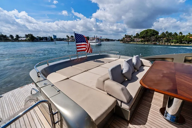 Slide: The Image of Luxurious 2013 AB 116 Motoryacht deck with sun loungers and dining table, overlooking scenic waterway. - 19