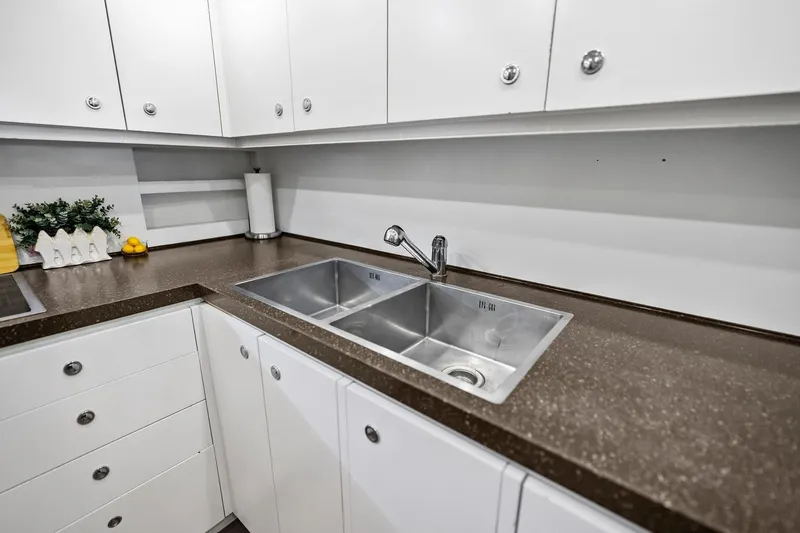 Slide: The Image of Modern kitchen sink area on 2013 AB 116 Motoryacht with sleek countertops and white cabinetry. - 38