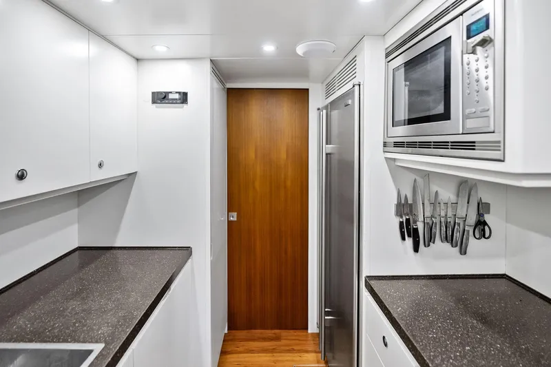 Slide: The Image of Modern galley kitchen on 2013 AB 116 Motoryacht with sleek countertops and stainless steel appliances. - 40