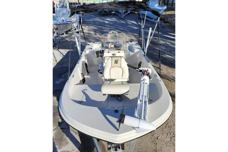 Slide: The Image of 2020 Carolina Skiff 162 JLS boat with canopy and seating, parked outdoors. - 11