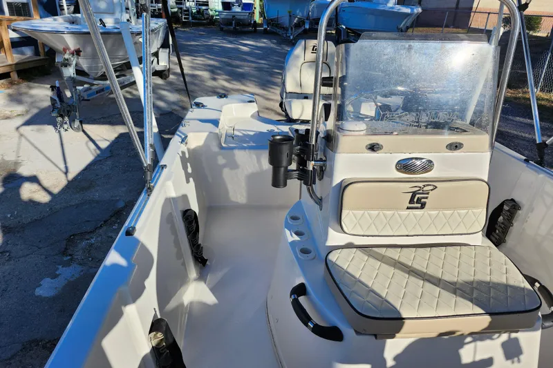 Slide: The Image of 2020 Carolina Skiff 162 JLS boat interior with seating and console, parked outdoors. - 16