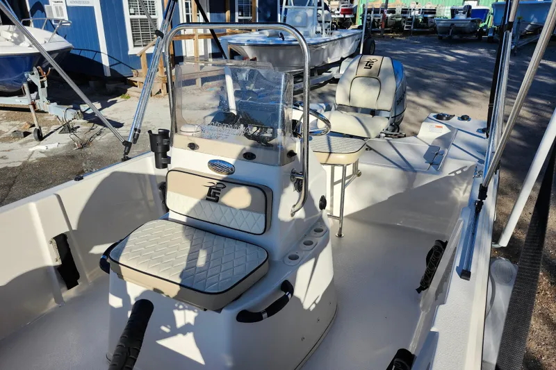 Slide: The Image of 2020 Carolina Skiff 162 JLS boat interior with seating and console, docked outdoors. - 17