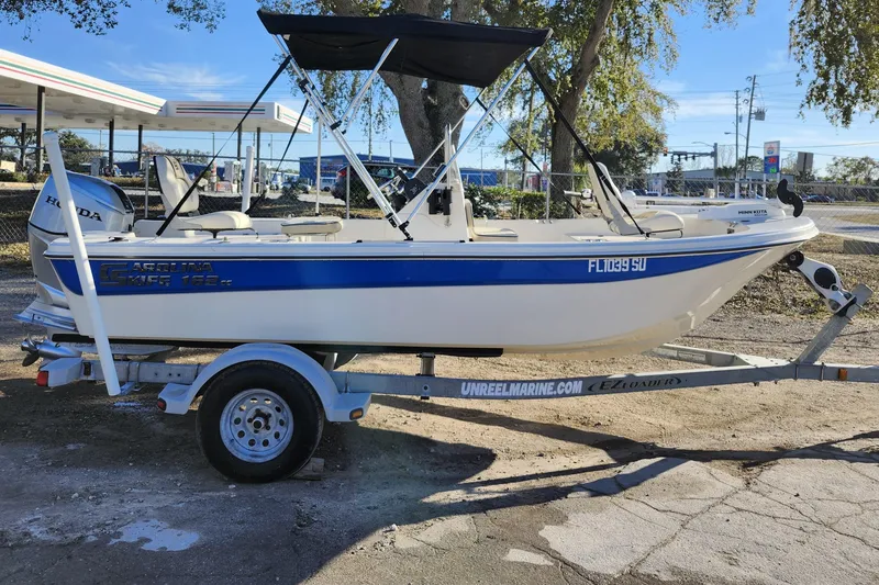 Slide: The Image of 2020 Carolina Skiff 162 JLS boat on trailer with canopy, parked outdoors. - 5
