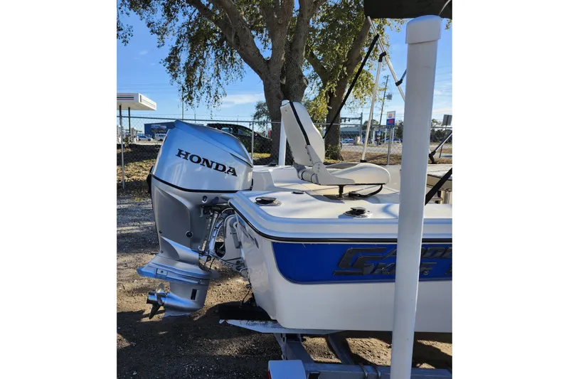 Slide: The Image of 2020 Carolina Skiff 162 JLS boat with Honda outboard motor, parked outdoors. - 9