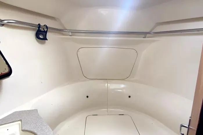 Slide: The Image of Interior cabin of 1997 Hunter 430 sailboat, featuring a clean, white design with storage space. - 14