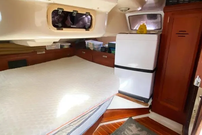 Slide: The Image of Cozy cabin interior of 1997 Hunter 430 sailboat with bed, storage, and fridge. - 16