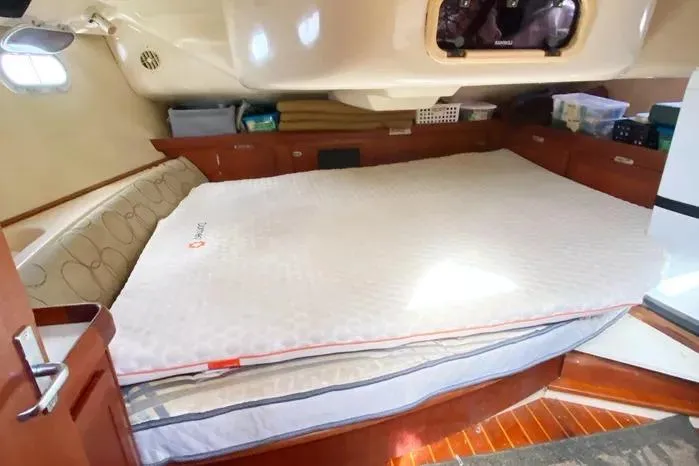 Slide: The Image of Interior cabin of a 1997 Hunter 430 yacht with a spacious bed and storage. - 19