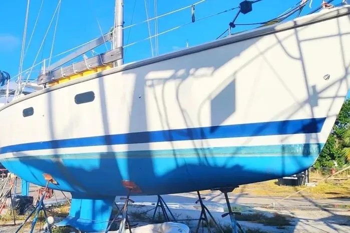 Slide: The Image of Hunter 430 sailboat from 1997 on dry dock, featuring a blue and white hull. - 6