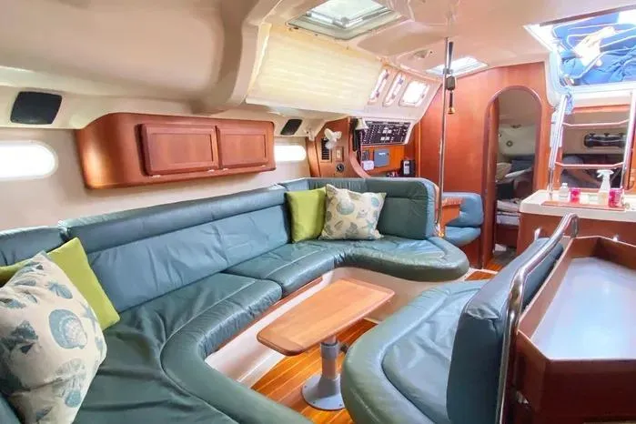 Slide: The Image of Interior of a 1997 Hunter 430 yacht with green seating and wooden accents. - 7