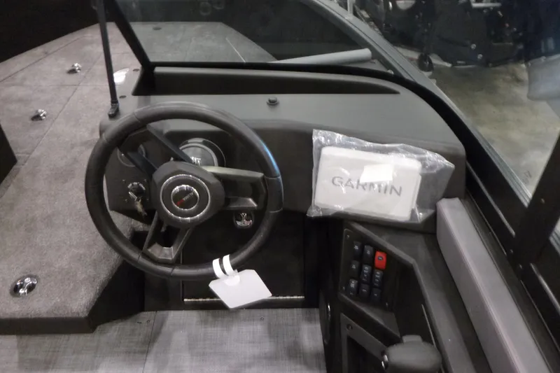 Slide: The Image of 2025 Alumacraft Trophy 185X Sport boat dashboard with steering wheel and Garmin device. - 11
