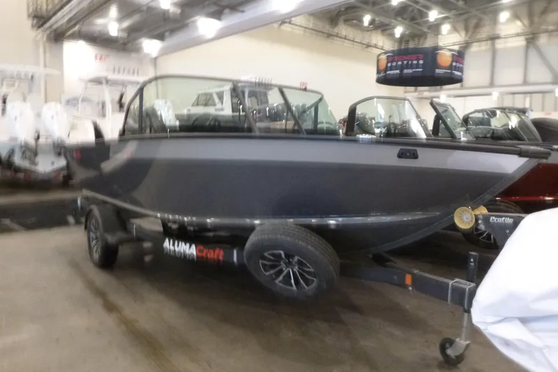 Slide: The Image of 2025 Alumacraft Trophy 185X Sport boat displayed indoors on a trailer. - 3