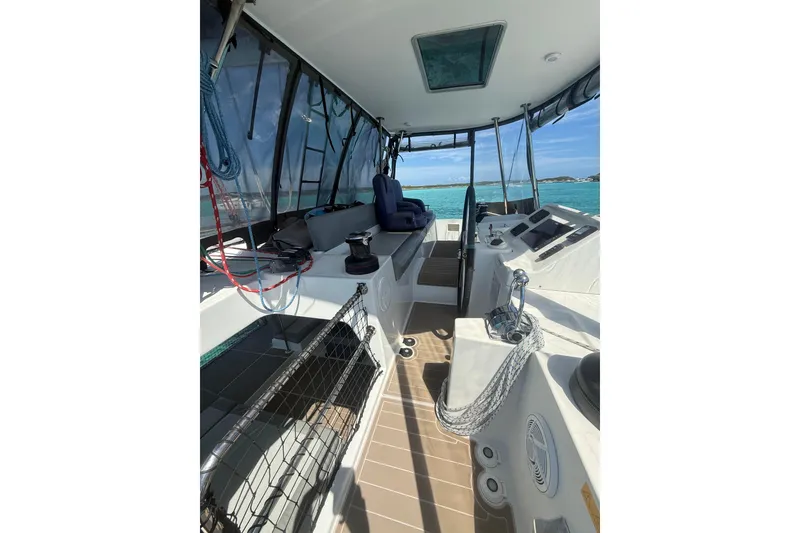 Slide: The Image of 2016 Lagoon 450 F catamaran cockpit with seating, steering wheel, and ocean view. - 14