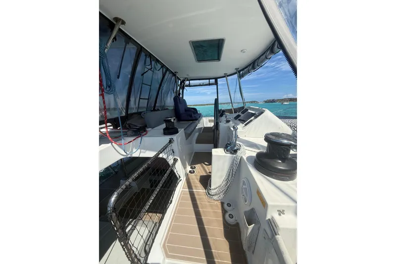 Slide: The Image of 2016 Lagoon 450 F yacht cockpit with ocean view, featuring navigation equipment and seating. - 15