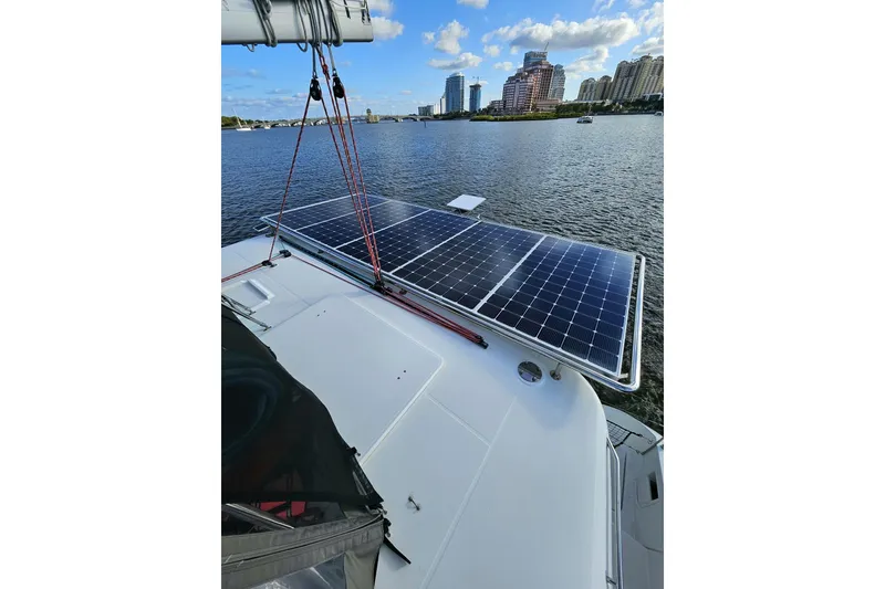 Slide: The Image of 2016 Lagoon 450 F catamaran with solar panels, docked near city skyline. - 17